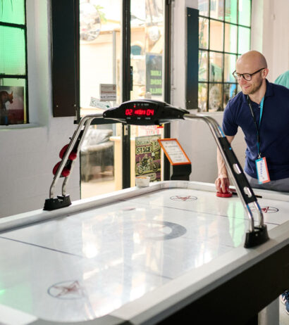 People smiling and playing air hockey