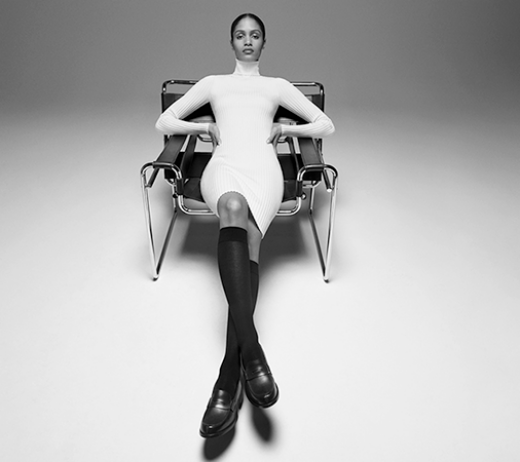 Black woman sitting on a design chair